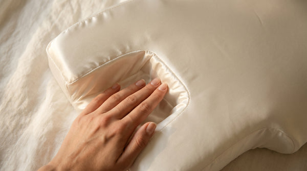 Eine Hand liegt in der Gesichtsmulde des MELYLA Anti-Falten Kissens
